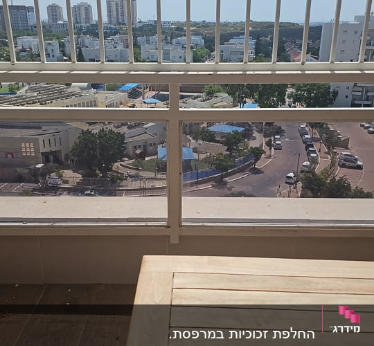 מרפסת עם מעקה זכוכית ונוף עירוני